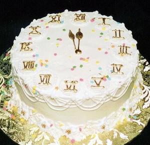 Шикарный новогодний торт в виде циферблата, цифры оформлены при помощи золотой пищевой краски и цветных кондитерских шариков