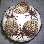 Новогодний торт, украшенный еловыми шишками, вырезанными из бисквита