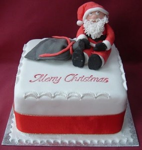 Красивый и вкусный новогодний торт в красно-белых тонах, украшенный марципановым Сантой