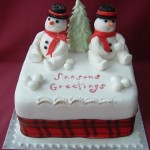 Возле ёлочки сидят два снеговика: так украшен торт для новогоднего стола