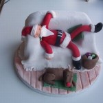 Отмечать Новый год нелегко. Этот новогодний торт оформлен в виде постели на которой Санта отдыхает после ночи подарков и его олень спит рядом с кроватью