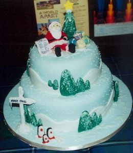 Многоярусный новогодний торт, украшенный ёлочками и Дедом Морозом из кулинарной мастики
