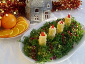 Украшаем салат свежим укропом, которые напоминают еловые ветви и свечками из сырного салата с пламенем-морковкой