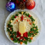 Сырный салат украшенный зеленью в виде рождественского венка и свечкой из сыра и моркови