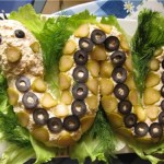Салат выложен в виде змеи из маслин и маринованых огручиков